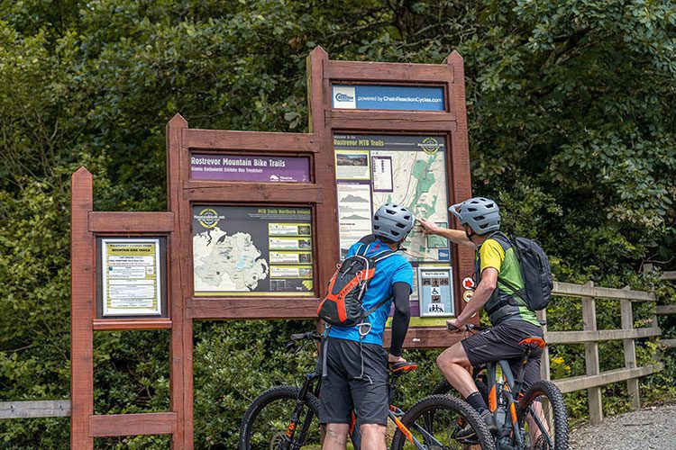 Trailhead-Rostrevor-Red-MTB-Bike-Mourne Two mountain bikers looking at the trailhead maps at Rostrevor near the Mourne Mountains